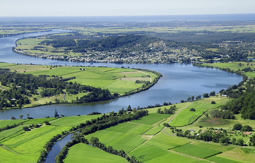 Aerial landscape shot of sugarcane farms and river